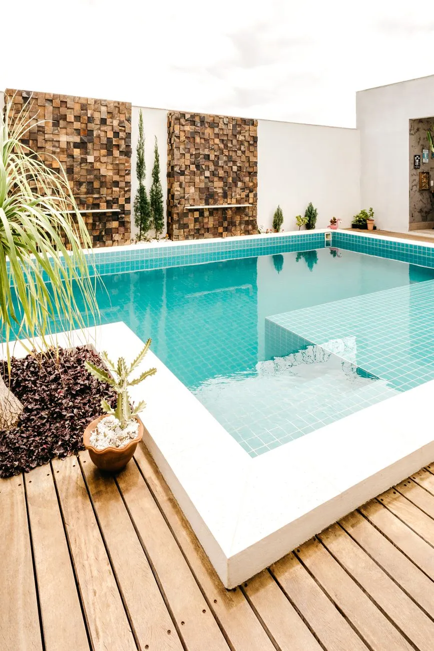 A timber deck wrapping a tiled backyard swimming pool